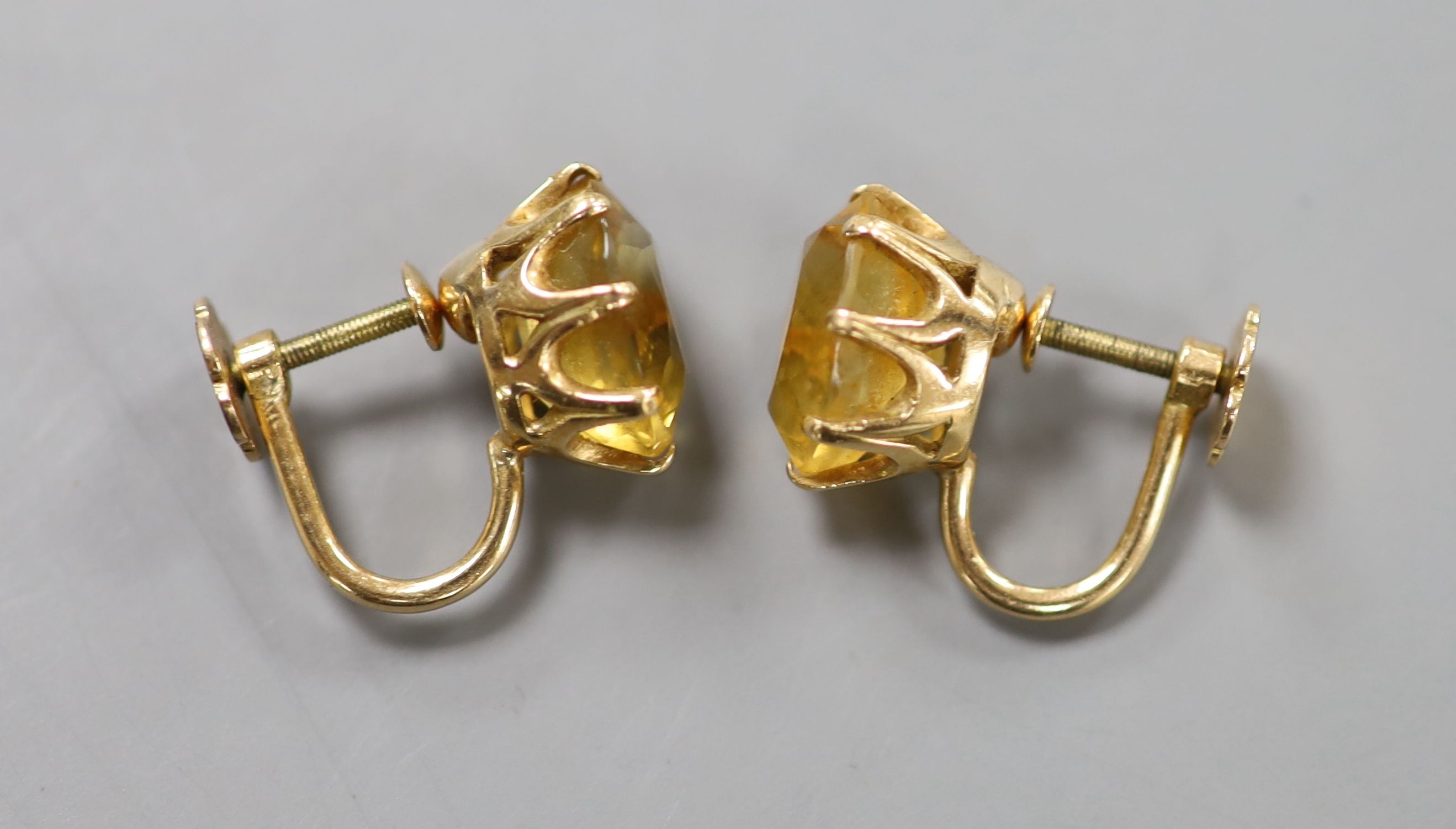 A pair of yellow metal and oval cut citrine set ear clips, 11mm, gross weight 5.7 grams.